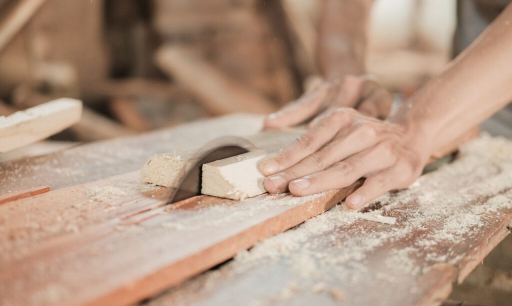 Ein Stück Holz wird mit einer Kreissäge gesägt.